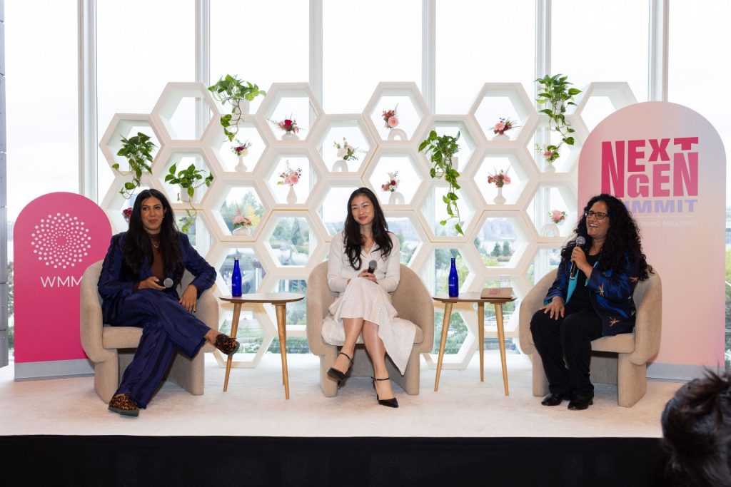 Sushma Raman and two other women sit on a stage with microphones.