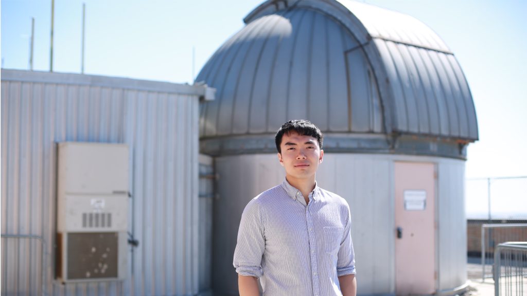 Quang Tran, standing outside and smiling at camera.