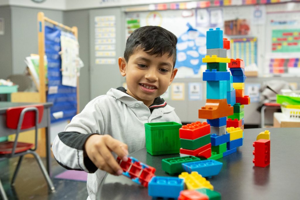 A young boy plays with building blocks.