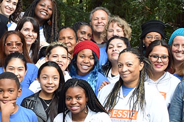 Group of people from the Essie Justice Group smile at camera.