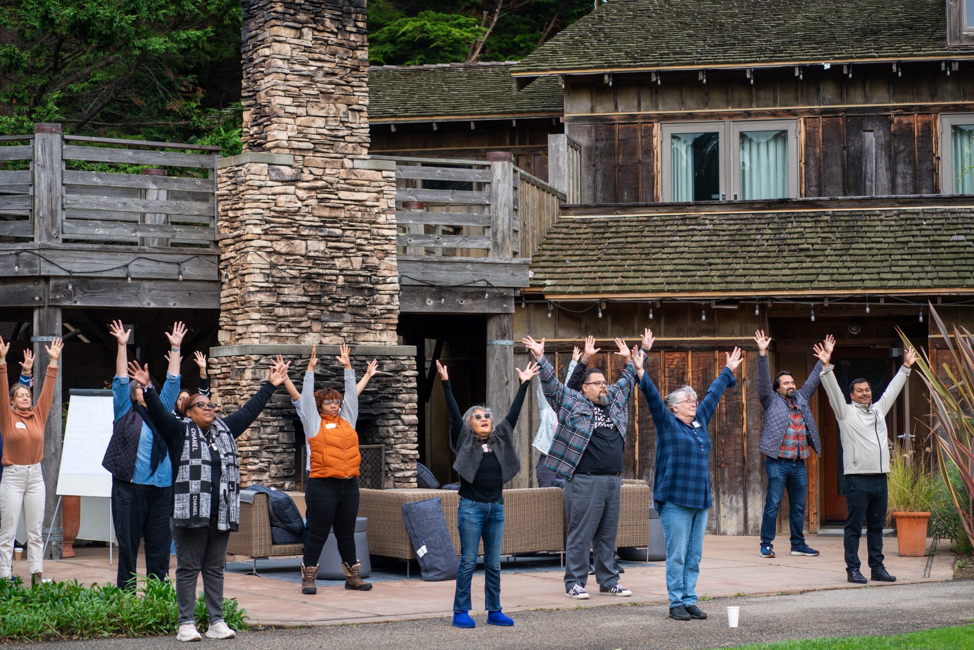 Group standing outside holding arms in the air.